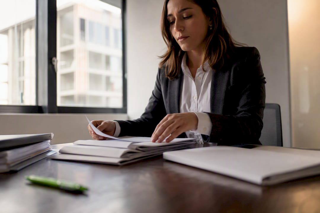 Manos organizando expedientes legales sobre el escritorio