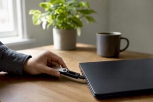 Cartera de criptomonedas física conectada a la laptop