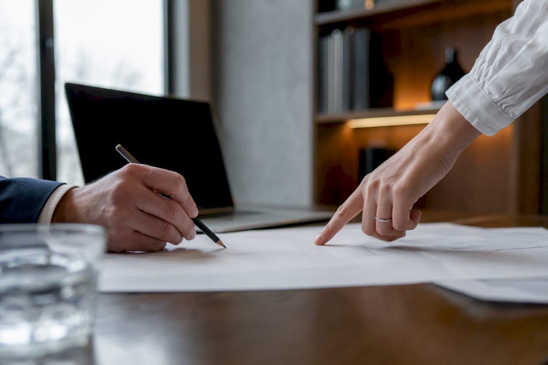 Manos colaborando sobre documentos en una oficina jurídica
